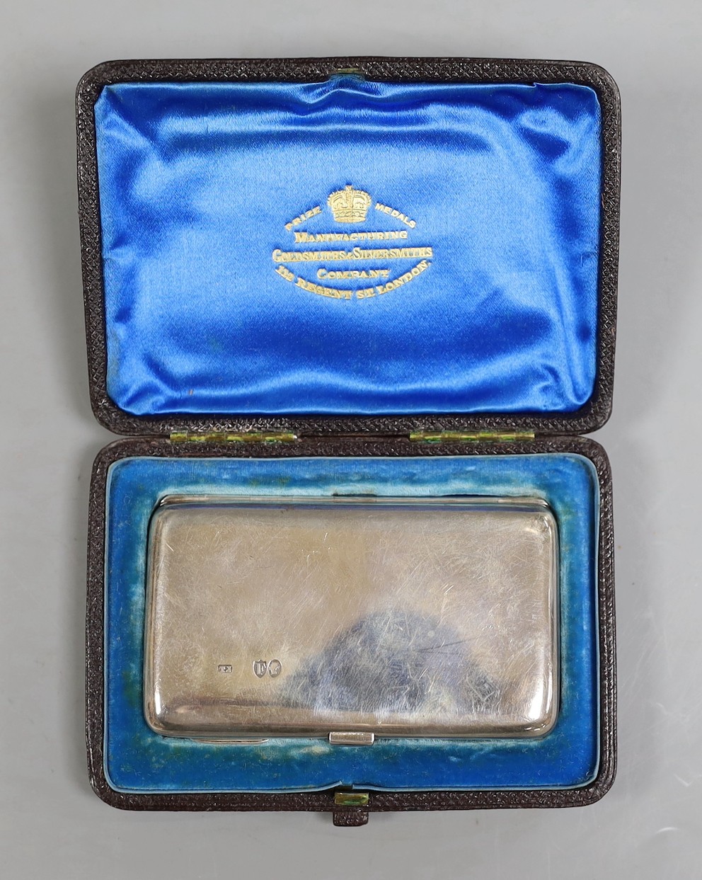 A cased late Victorian silver mounted purse, London, 1883, 82mm, together with a later engine turned silver mounted compact.